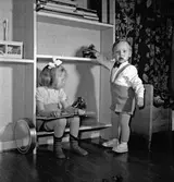 Familjen Arne Malm, Birgitta och Göran leker med dalahästar i hemmet