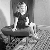 Flicka på pall i hemmet.
Familjen Arne Hedén.