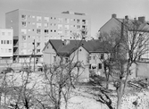 Kvarlämnat rivningshus framför nya hyreshus på Drottninggatan, 1960-tal