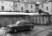 Bil parkerad vid förådsbyggnad på Karlslundsgatan 14, 1970-tal