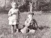 Syskonen Karl Hugo och Maj Svensson äter äpplen. De var fosterbarn hos 