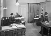 Från vänster: Amelie Hesselgren vid skrivmaskin, Mina Sandsjö och
Karolina Kraeppelin, den första som skrev maskin i posten, Ester
Carlsson. Amelie Hesselgren var den första kvinnan i poststyrelsen.
Hon skrev kungaskrivelserna för hand. 