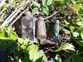 Flera glasflaskor av olika slag hittades i schakten på terrassen L2022:9251. Från arkeologisk utredning vid Alborgen, Valbo socken, Gävle kommun.
