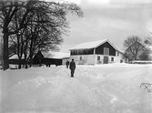 Män i spårsnö framför lada i Ramsberg, 1920-tal