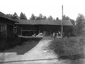 Pojke framför lada med vedhög i Ramsberg, 1920-tal