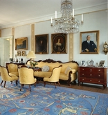 Interiör från Blekhem i Småland. Stora salongen med möbel i nyrokoko, matta vävd efter mönster av Maja Sjöström och Ehrenstrahlporträtt över soffan.