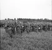 En grupp soldater från Hälsinge Regemente, I 14, ute på manöver. I framkant till vänster i bild står en fänrik med en kartväska.