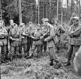 En fänrik illustrerar med en lång pinne en manöver för en grupp soldater från Hälsinge Regemente, I 14