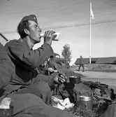 En soldat från Hälsinge Regemente, I 14, avnjuter en måltid vid sitt fältkök