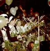 Kvinlig student omgiven av andra firande studenter