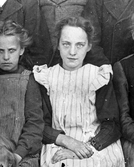 Avfotograferad del av ett gammalt familjepoträtt, fokus på en flicka i finkläder
