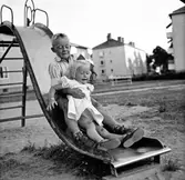 Syskonbild, bror och syster på en rutschkana