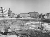 Pålkran i arbete vid byggnation av Krämaren schakt mot Våghustorget, 1960-03-11