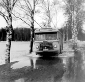 Buss på väg mot Örebro kör på översvämmad väg i Ervalla, 1977