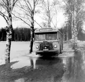 Buss på väg mot Örebro kör på översvämmad väg i Ervalla, 1977