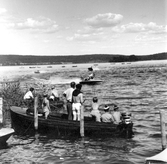 Åskådare i båt tittar på båttävling på Norasjön, 1949