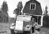 En lastbil från Gustaf Ehlins Åkeri (GE) transporterar en stuga