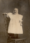 Glad flicka på stol i Brockton i USA, 1901