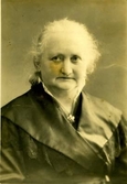 Kvinnoporträtt. Äldre kvinna med bred, blank krage och halsbrosch.