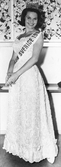 Siv Åberg, vinnare av Fröken Sverige-tävlingen 1964. Klädd i långklänning, klänning och axelgehäng.