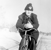 Banvakt Pettersson på cykel en vinterdag i Adolfsberg, 1950-tal