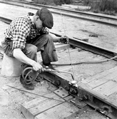 Banarbetare Bernt Eriksson löder en skarv på rälsen, 1950-tal