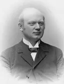 Ateljéporträtt av August Bondeson klädd i kavaj, fluga. Bröstbild, visitkort.