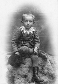 Från August Bondesons vänkrets. Gösta Pherson i Sjönevad som pojke. Gösta är klädd i ribbstickade strumpbyxor, kängor och kolt med blanka kulknappar och spetskrage.