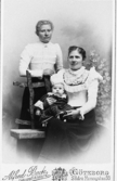 Ateljéporträtt av systrarna Karolina (1874 - 1962) och Charlotta (1871 - 1956, gift Johansson) Börjesson med sonen Reinhold Johansson (1900 - 1917) i sitt knä. Okänt årtal, Apelgården 1:6 