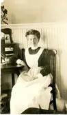 Anna Eriksson (född 1881 i Bölet, död 1952 i Vommedal), sitter på en stol i ett rum i USA år 1905. Dotter till Alida och Johannes Eriksson, Bölet. Anna emigrerade 1905 (fotot taget då) till USA och arbetade i familj. Hon återvände till Sverige 1920 och gifte sig med Vitalis Efraimsson.
Relaterat motiv: 3328.