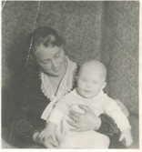Lisa Johansson (1898 - 1997) sitter med sonen Bengt (1930 - 2016) i knäet, Labacka Lund år 1930.