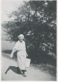 Lisa Johansson (1898 - 1997) bär en mjölkespann, Labacka Lund 1930-tal.