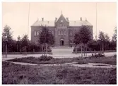 Elementarläroverket för gossar på Engelbrektsgatan i Varberg, uppfört 1893. Träden har fortfarande kvar sina stöttor sedan planteringen.