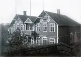 Ur byggmästare Johannes Nilssons fotoalbum från 1914. Folkets Hus i kv Lilla Kari uppfördes 1898 som ordenshus för nykterhetsföreningar. Sannolikt ledde Nilsson ombyggnaden då huset bl a fick ett balkongparti över entrén och gavlarnas snickerier avlägsnades. 
(Se bildnr G19924 för husets tidigare utseende)