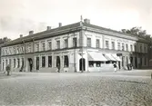 Ur byggmästare Johannes Nilssons fotoalbum från 1914. Hörnfastigheten p å Kungsgatan 22-Torggatan 7 sedd från torget. Byggnaden uppfördes 1769 och ersatte ett tidigare trähus som förstörts i den stora stadsbranden den 18 maj 1767. Byggherre var handlaren och rådmannen Peter Hierton från Eftra och hans hustru Barbara Gammal. Hennes föräldrar ägde ett tobaksspinneri i Varberg. Ritningarna utfördes av Sven Kellander, kommendant på Varbergs fästning, senare adlad Mannerskantz. Byggmästare var tysken Friedrich August König (senare Rex), som även byggde kyrkan tvärs över gatan. I rummet i hörnet mot torget finns ett stucktak från 1769 bevarat med allegoriska framställningar av de fyra stånden och initialerna B.G. och P.H. för byggherreparet och F.A.K. för byggmästaren. 

Mellan 1864-1897 ägde handlanden Adolf Lundquist huset och han lät bygga om det 1865, då det fick nuvarande klassicerande fasad. Byggnaden kallas efter honom det Lundquistska huset.

I bottenvåningen ligger Carl Nilsson och Son:s järnaffär och till höger i bild försäljs lampor och glas. En man korsar gatan bärande en apparat med slang.