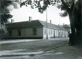 Ur byggmästare Johannes Nilssons fotoalbum från 1914. Timrad byggnad uppförd 1874 i hörnet Norra Vallgatan-Drottninggatan, kv Postmästaren.