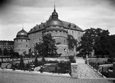 Bil och cyklister på Kvarnbron på väg mot Örebro slott, 1930-tal