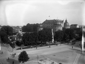 Människor flanerar längst Storgatan förbi Karl Johan-statyn, 1920-tal