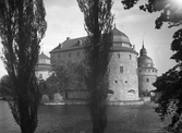 Örebro slott sett genom centralparkens trädkronor, 1930-tal