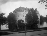 Örebro slott sett genom träden i centralparken, 1930-tal