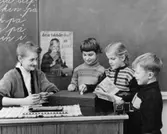 Lärarinnan fröken Gunilla Lagerblad övervakar insättningen i
skolsparbössan.