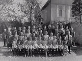Skolfoto från Grimeton med skolan i bakgrunden och skolläraren i mitten är troligen Patrik Nilsson.