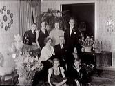 Kyrkoherde Sjöblom med familj i vardagsrum.