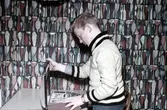Ung man tittar på foton på ungdomsgård i Örebro, 1950-tal