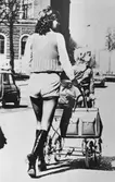 Gävle stad – Norr. Vid Rådhuset, juni 1970.
Moderiktig småbarnsförälder på shoppingtur.