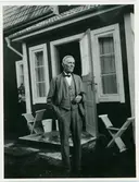 En äldre man utanför ett bostadshus, Söderby-Karl, Uppland