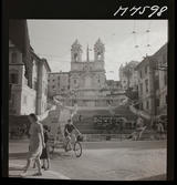 1717/B Rom. Spanska trappan i Rom. En ung man cyklar föbi med en reklamskylt fastmonterad bakpå cykeln.