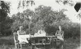Fyra personer sitter och fikar i trädgården, Backen eller Högen (nedre gården), okänt årtal. Från vänster: 1. Matilda Pettersson. 2. Gunnar Pettersson. 3. drängen Alfred Johansson. 4. Karl Gustav Pettersson. Matilda var faster till bröderna Gunnar och Karl Gustav.
