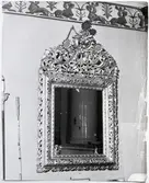 Strömsbergs gård, Jönköpings län, interiörer med spegel med praktfull guldram. I spegelglaset återspeglas en kakelugn.

Text på fotografiets baksida: Ljungarun sn / SMÅL. STRÖMSBERG / Foto Erik Liljeroth 1968. Stämpel: JÖNKÖPINGS LÄNS MUSEUM.