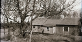 Fållses stuga i Järlöv (stavas även Folses, Fålses). Fasaden är omålad, taket belagt med stickspån (pärt) och fönsterluckan till höger har ett titthål.